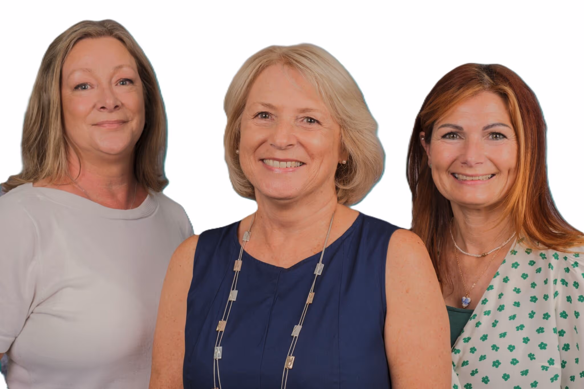 Three smiling women stand together, facing the camera against a plain background.